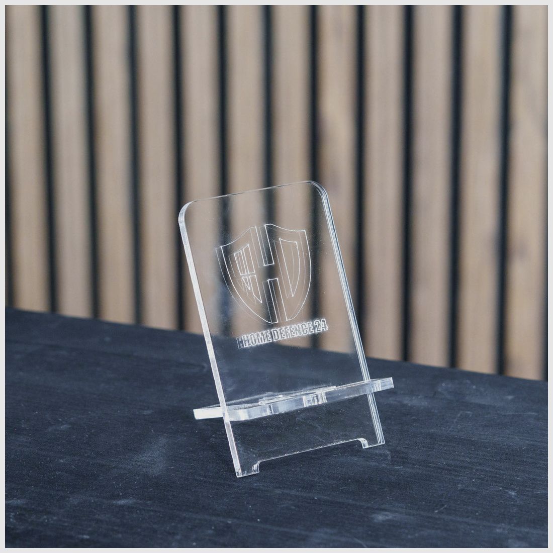 PLEXIGLAS® Handyhalterung | stilvolles Design mit gelasertem Homedefence-Logo