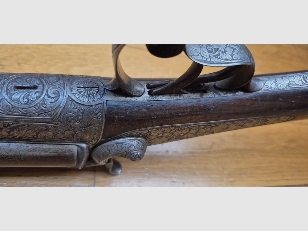 Très beau fusil de chasse juxtaposé à broche – Signé sur la bande des canons « Maison de l’Inventeur Lefaucheux – 37 rue Vivienne à Paris » – Canons damas superbe – Cal 16 broche – Bronzage à 85% – Magnifiques gravures en garnitures et pièces – Toutes vis guillochées – Plaque de couche ébène – Très beau noyer rouge – Excellent état mécanique – Pas de jeu – Canons à âme encore très propre malgré une oxydation ancienne – Et un « VRAI » Lefaucheux ! – Arme en TBE global – TBE, image 13 sur 47