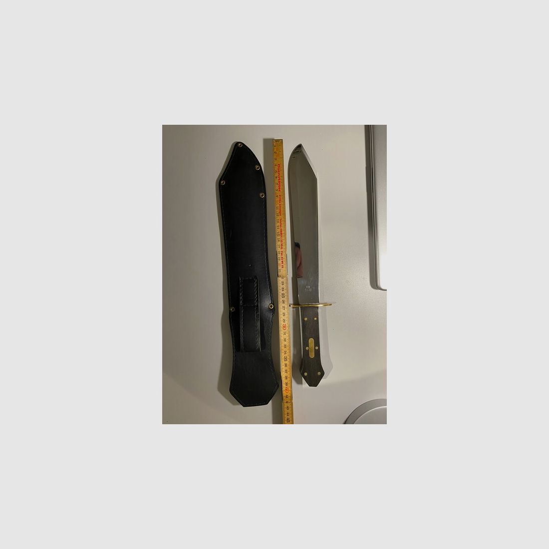 Schönes massives Jagdmesser mit schwarzer Messerscheide aus Leder und Skullprägung