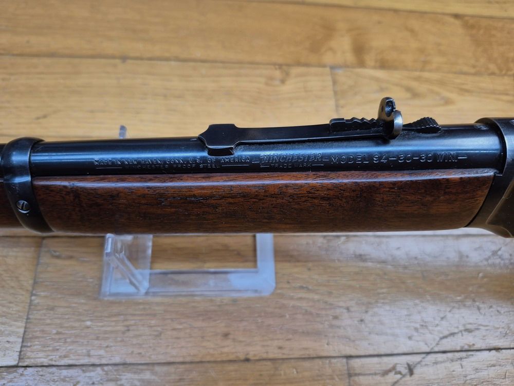 Prachtige Winchester 94 – Uitzonderlijke fabricage voor 1964 – Kal. .30.30 Win – Echte fabricage New Heaven Made in USA – Prachtig hout met fijne nerf – Onberispelijke originele bluing – Krokodillenvisier van gesmeed staal (en niet gestanst) – Uiterst soepele mechaniek – Minimale speling – Sublieme loop – Het beste van Winchester in museale staat!, afbeelding 14 van 21