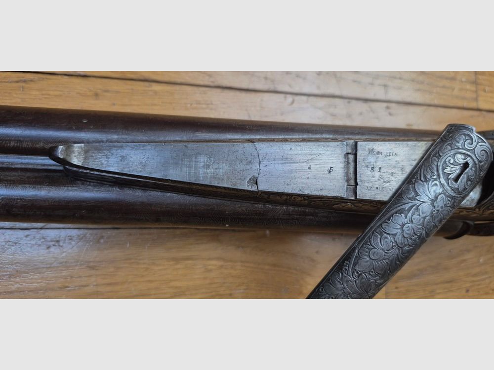 Sehr schönes Seitengewehr – Signiert auf der Laufbande „Maison de l’Inventeur Lefaucheux – 37 rue Vivienne in Paris“ – Wunderschöne Damaschusläufe – Kal. 16 – Brünierung bei 85% – Wunderschöne Gravuren an Beschlägen und Teilen – Alle Schrauben guillochiert – Schaftplatte aus Ebenholz – Sehr schönes rotes Nussbaumholz – Ausgezeichneter mechanischer Zustand – Kein Spiel – Läufe innen noch sehr sauber trotz alter Oxidation – Und ein „ECHTER“ Lefaucheux! – Waffe in TBE insgesamt – TBE, Bild 45 von 47