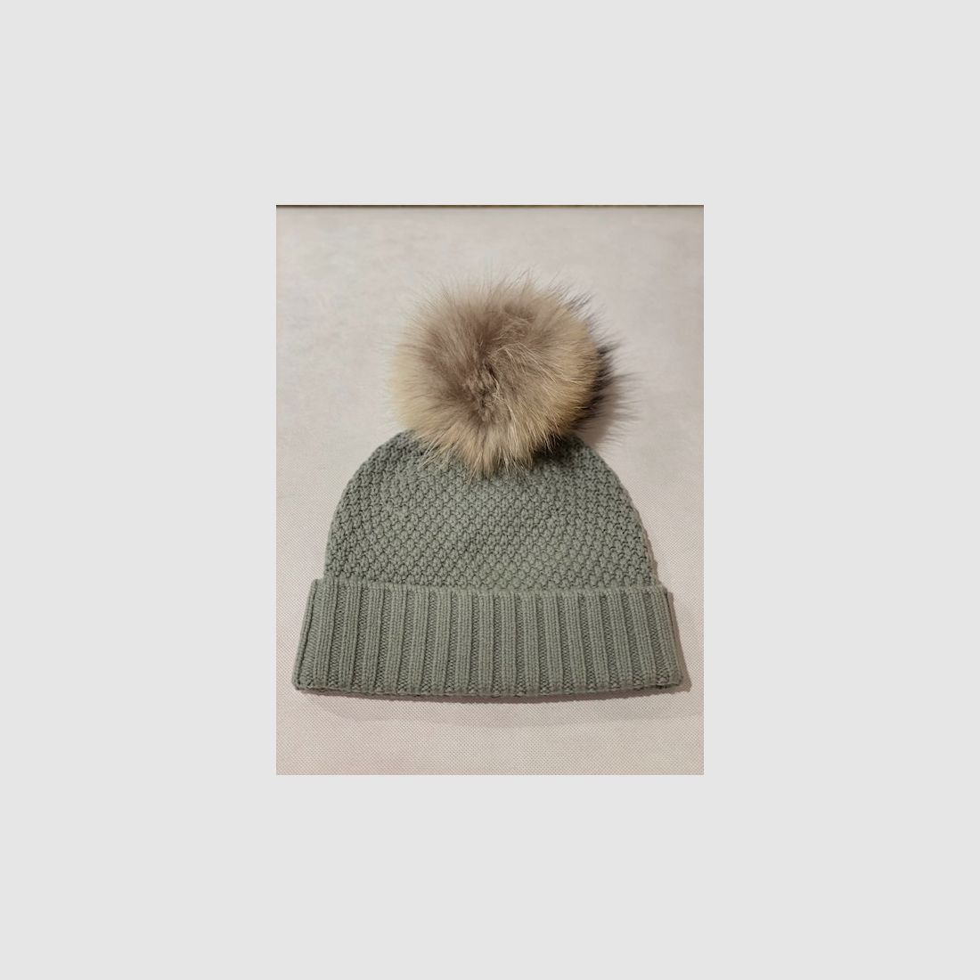 Bonnet en tricot Schneiders avec pompon en raton laveur finlandais en menthe