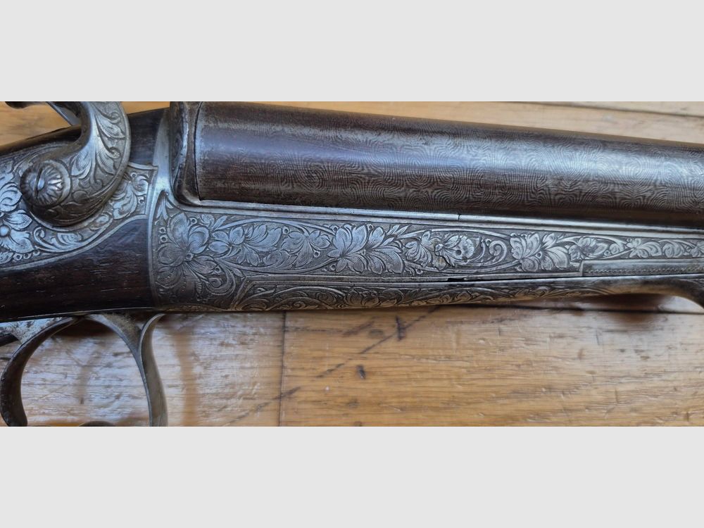 Très beau fusil de chasse juxtaposé à broche – Signé sur la bande des canons « Maison de l’Inventeur Lefaucheux – 37 rue Vivienne à Paris » – Canons damas superbe – Cal 16 broche – Bronzage à 85% – Magnifiques gravures en garnitures et pièces – Toutes vis guillochées – Plaque de couche ébène – Très beau noyer rouge – Excellent état mécanique – Pas de jeu – Canons à âme encore très propre malgré une oxydation ancienne – Et un « VRAI » Lefaucheux ! – Arme en TBE global – TBE, image 40 sur 47