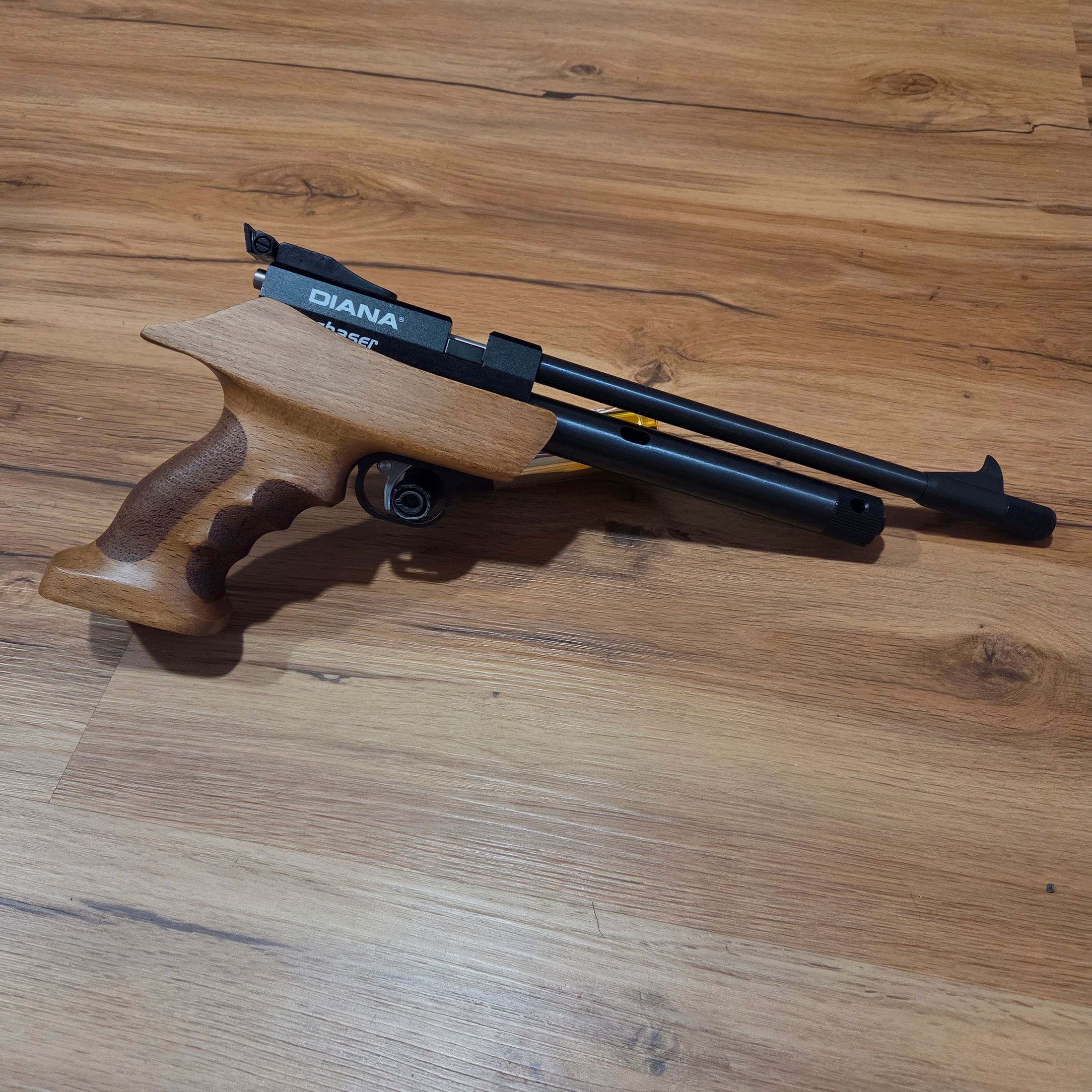 Diana Chaser mit Holzgriff und einer Packung Diabolos