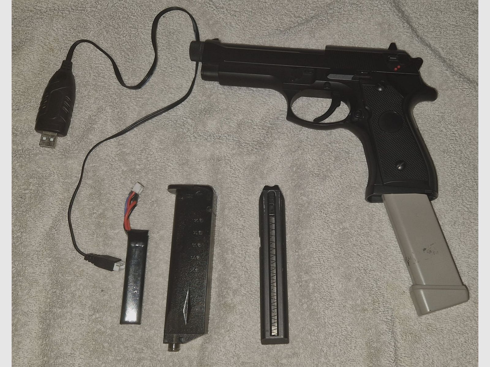 Cyma CM.126 (Mosfet and tracer thread) with an 80 BB mag in gray, charging cable, battery, and speedloader