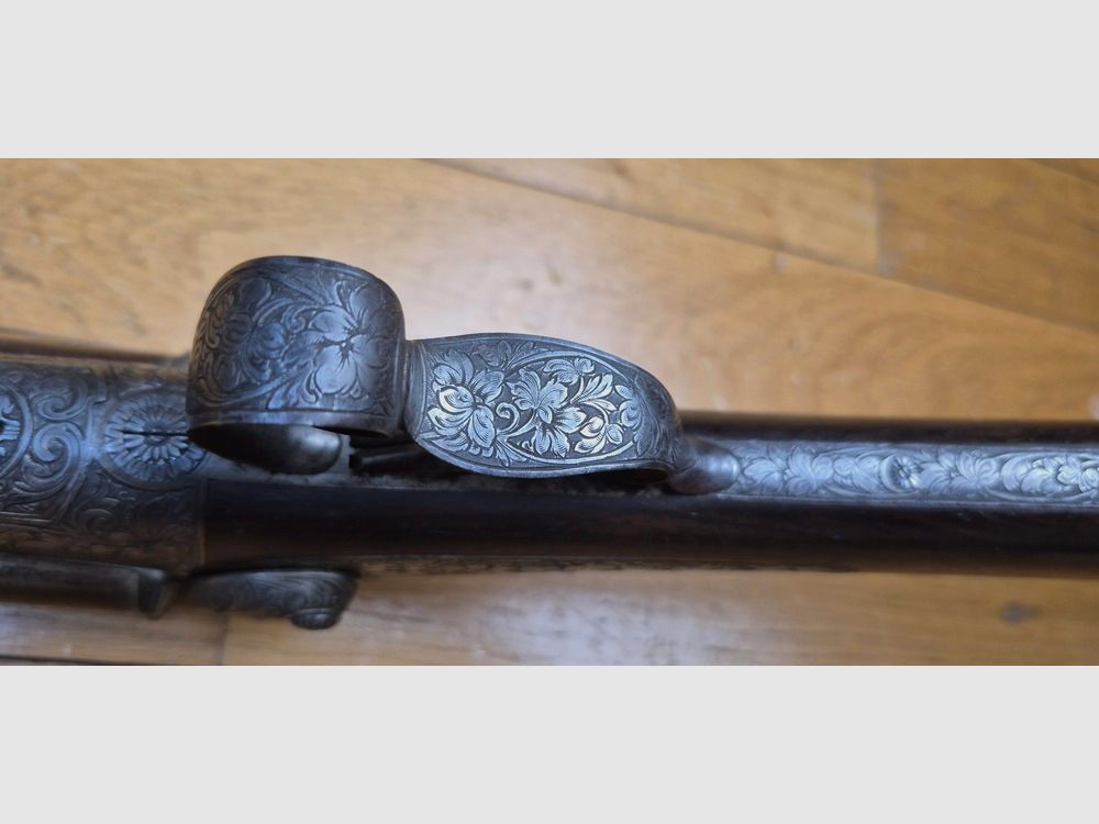 Sehr schönes Seitengewehr – Signiert auf der Laufbande „Maison de l’Inventeur Lefaucheux – 37 rue Vivienne in Paris“ – Wunderschöne Damaschusläufe – Kal. 16 – Brünierung bei 85% – Wunderschöne Gravuren an Beschlägen und Teilen – Alle Schrauben guillochiert – Schaftplatte aus Ebenholz – Sehr schönes rotes Nussbaumholz – Ausgezeichneter mechanischer Zustand – Kein Spiel – Läufe innen noch sehr sauber trotz alter Oxidation – Und ein „ECHTER“ Lefaucheux! – Waffe in TBE insgesamt – TBE, Bild 12 von 47