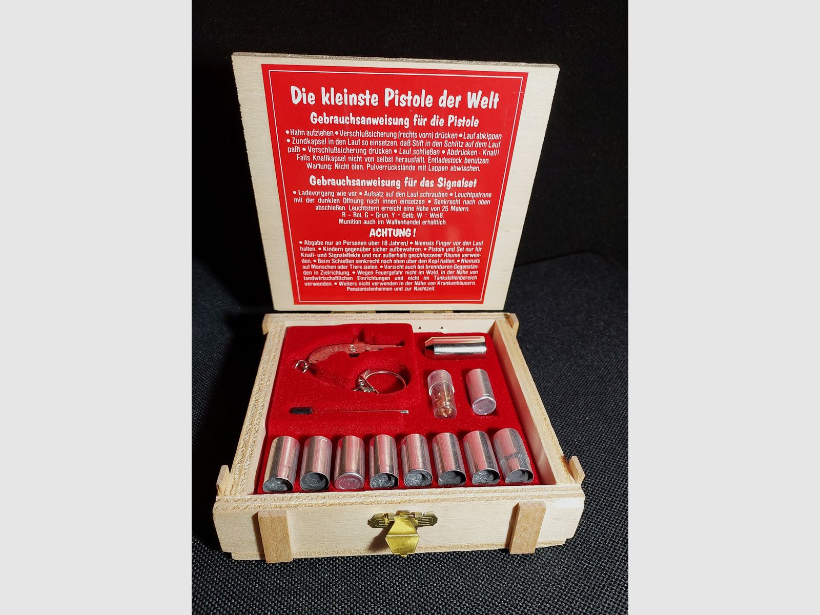 Original Berloque Mini Pistola niquelada incluyendo cápsulas de explosión y estrellas brillantes en caja de madera calibre 2 mm (P18)